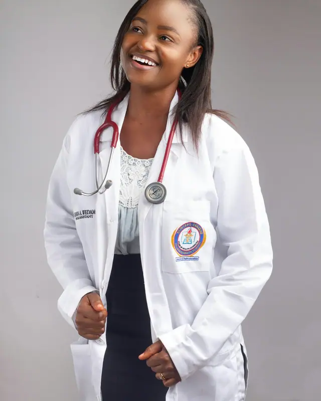 Renata Lopes, terapeuta corporal, sorrindo, de jaleco claro